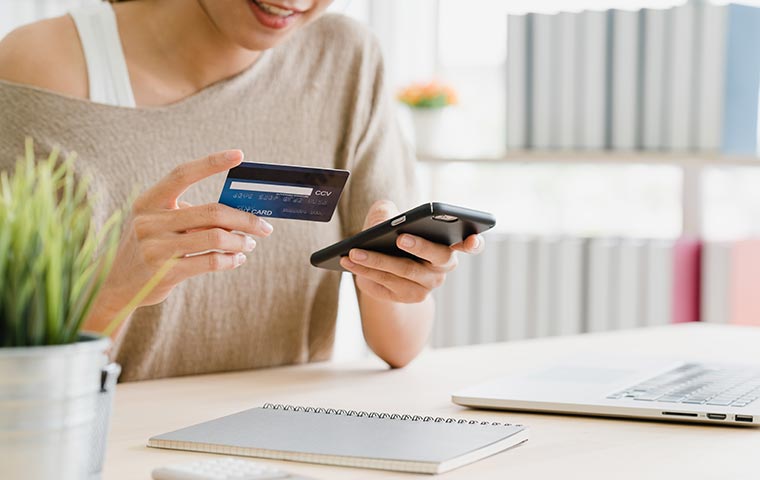 A photo of a woman uses a smartphone for online shopping with the technology of woocommerce amp